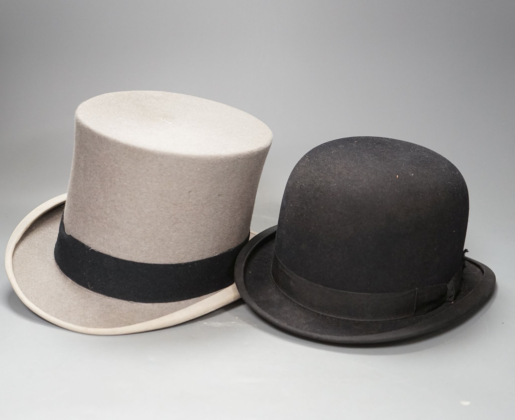An Army & Navy Stores Ltd. grey top hat and a Christys of London black riders bowling hat, both boxed